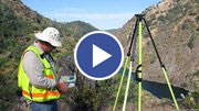 image of a surveyor using a tri-pod to survey